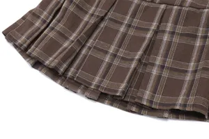 Detalle del tejido de falda plisada a cuadros marrón y acabado del dobladillo plisado