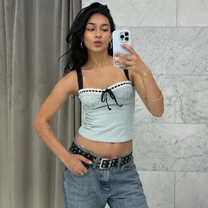 Mirror selfie showing details of a light green camisole with black lace and bow
