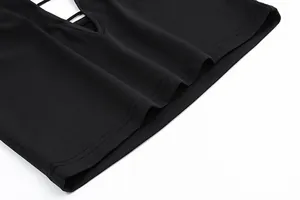 Vue détaillée des coutures de l'ourlet et de la texture d'un crop top noir à col licou évidé