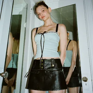 Chic lace trim camisole and leather mini skirt outfit on model with mirror reflections