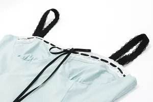 Close-up detail showing the lace trim and black ribbon bow on a light blue camisole top
