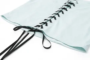 Detail view of a mint green sexy camisole featuring stylish black lace-up ribbon