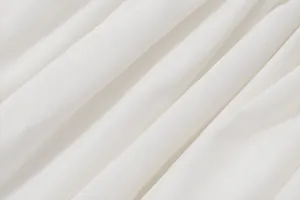Macro shot showing the fine pleated texture of white breathable summer dress fabric