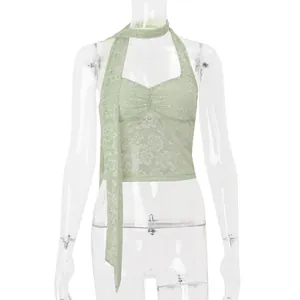 Dettaglio di un top all'americana in pizzo verde con sciarpa coordinata su manichino.