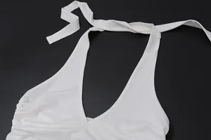 Detailed view of white halter neck top with adjustable tie straps and pleated side detail