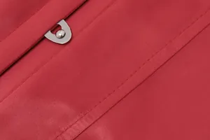 Gros plan sur la boucle métallique durable et les coutures précises du tissu rouge.