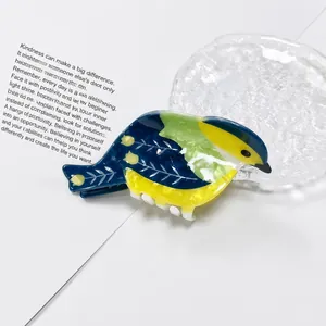 Primer plano detallado de una linda pinza para el pelo de urraca en PVC azul y amarillo vibrante