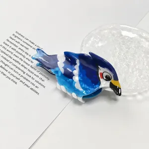 Nahaufnahme einer niedlichen Blauhäher-Haarklammer aus glänzendem PVC-Material.
