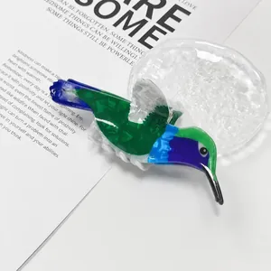 Vista detallada de una pinza para el cabello colorida con forma de colibrí para peinado mujer.