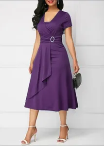 Detail view of a purple V-neck dress featuring an asymmetric hem and buckle waist detail