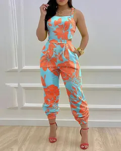 Detail view of floral print jumpsuit with vibrant orange flowers on light blue fabric.