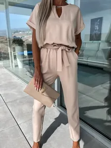 Elegante tuta beige con scollo a V, maniche corte e cintura in vita regolabile.
