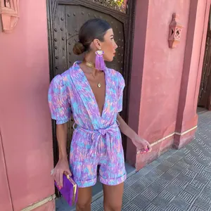 Vibrant purple printed V-neck belted romper for summer street fashion style.