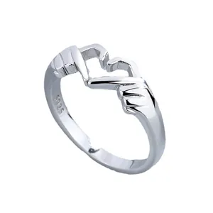 Detail view of a 925 sterling silver ring with a romantic heart hand gesture carving.