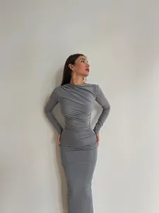 Robe longue moulante grise élégante à manches longues avec détails froncés et col rond.
