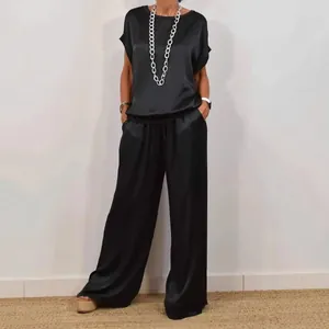 Elegant black satin two-piece set with loose short sleeve top and wide leg pants