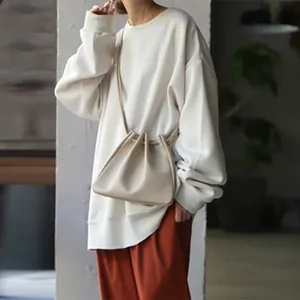 Detail shot of oversized cream women's sweatshirt with loose fit and soft fabric texture