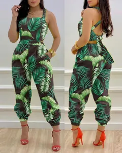Tropical green palm leaf print halter jumpsuit with open back and bow tie detailing