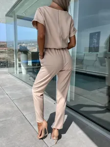 Elegante tuta beige a maniche corte con cerniera sulla schiena e vestibilità aderente