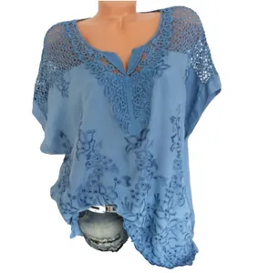 Detailansicht der blauen V-Ausschnitt-Spitzenbluse mit Stickerei und Fledermausärmeln.