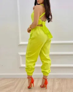 Back view of neon yellow open back jumpsuit with large bow and high waist detail