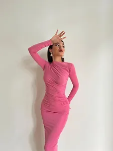 Détail d'une élégante robe longue moulante rose à manches longues et fronces