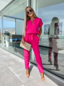 Tuta fucsia a maniche corte con scollo a V e cintura per un look estivo elegante