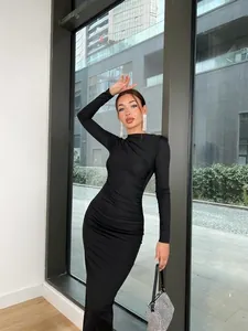 Robe longue moulante noire à manches longues avec détails drapés élégants sur un mannequin
