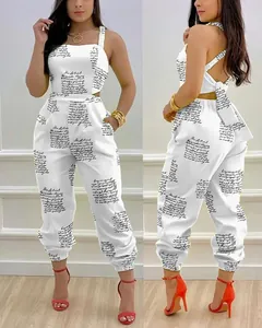 Detail view of a white backless jumpsuit featuring cursive print and a back bow tie