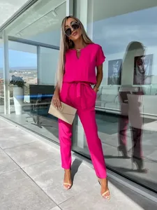 Tuta fucsia a maniche corte con scollo a V e cintura in vita indossata da una modella