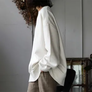 Oversized white crewneck sweatshirt detail showing relaxed fit and soft minimalist style