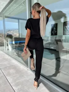 Vista posteriore di un'elegante tuta nera con scollo a V e maniche corte chic