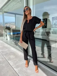 Elegante tuta nera con scollo a V, maniche corte e cintura in vita per un look moderno