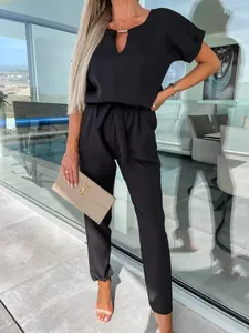 Elegante tuta nera con scollo a V, maniche corte e cintura in vita dal design moderno