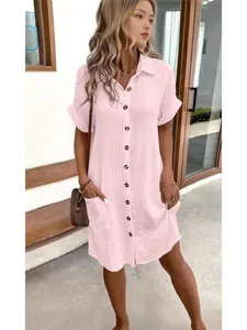 Close-up detail of casual pink cotton linen shirt dress with brown buttons and front pockets