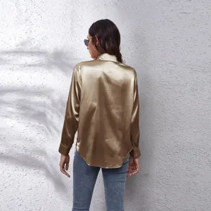 Detailansicht der Rückseite eines champagnerfarbenen Satin-Langarmshirts mit edlem Glanz