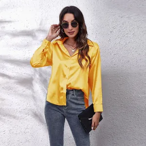 Nahaufnahme der glänzenden gelben Satin-Langarm-Bluse mit Knopfleiste für Damen