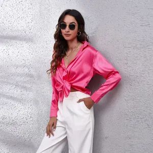 Detailansicht der stylischen pinkfarbenen Satinbluse mit einem modernen Knotendesign