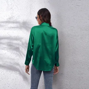 Detaillierte Rückansicht einer leuchtend grünen Satinbluse mit glänzendem Finish