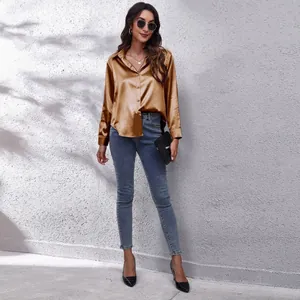 Elegantes bronzefarbenes Satinhemd mit langen Ärmeln und blauen Skinny-Jeans für Damen