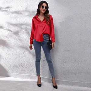 Elegantes rotes Satinhemd mit langen Ärmeln und schmal geschnittenen blauen Jeans