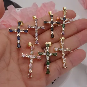 Macro detail of colorful zircon waterdrop cross pendants in gold-plated settings
