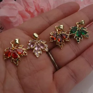Close-up of four maple leaf pendants with colorful cubic zirconia in hand
