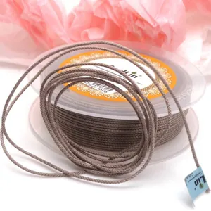 Primo piano di cordino in cotone mambo marrone da 1,5 mm su rocchetto per gioielli fai da te