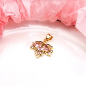 Close-up of a gold-plated maple leaf pendant with pink and lavender zircons