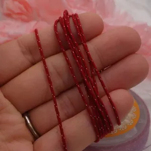 Macro view of red braided cotton cord with gold metallic thread for DIY jewelry