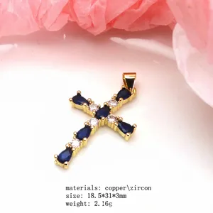 Close-up of elegant gold plated cross pendant featuring teardrop blue zircon stones