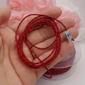 Close-up of red braided cotton cord with gold metallic thread for DIY jewelry making