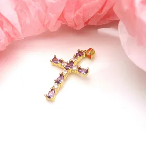 Detailed macro view of a gold-plated cross pendant featuring purple teardrop zircon stones