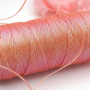 Detailansicht von schimmerndem 0,5 mm rosa und goldfarbenem Wachsfaden für DIY-Schmuckwebereien